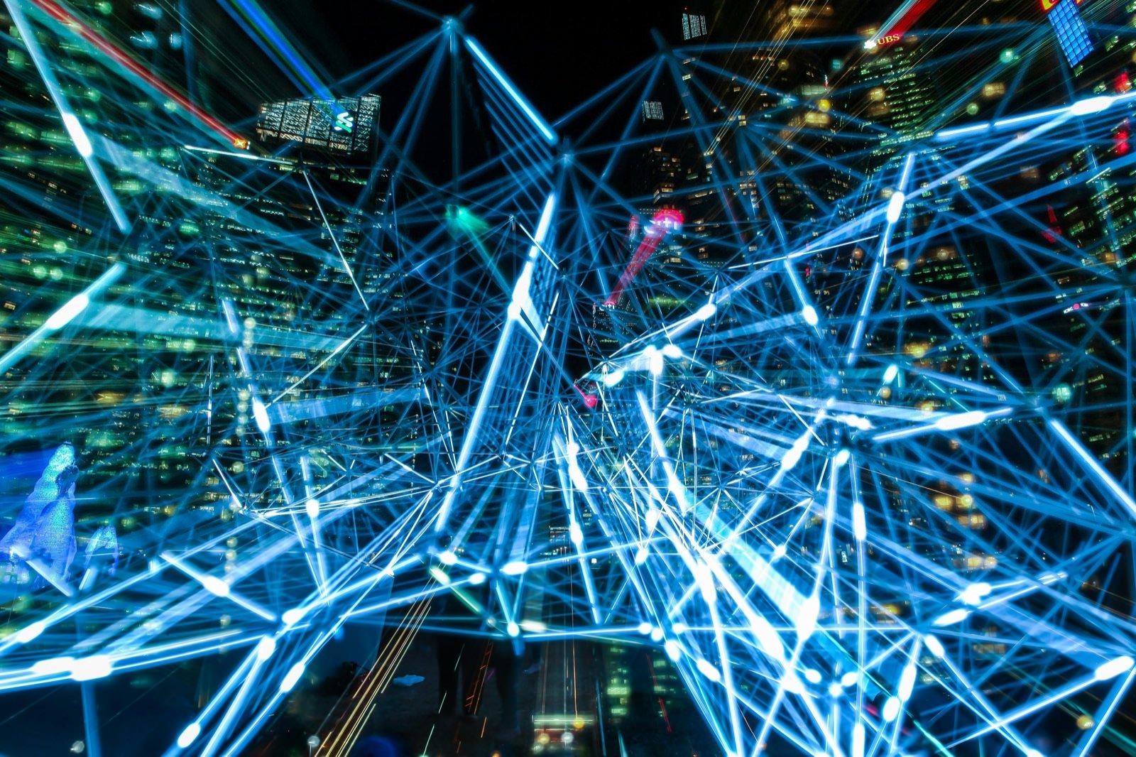 Night city scene layered with glowing blue network lines and digital connections.